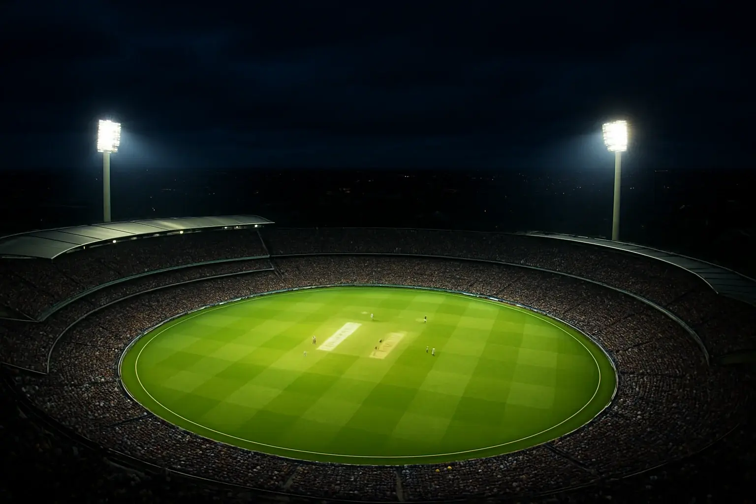 Aerial night view of cricket stadium with floodlights and vibrant green pitch